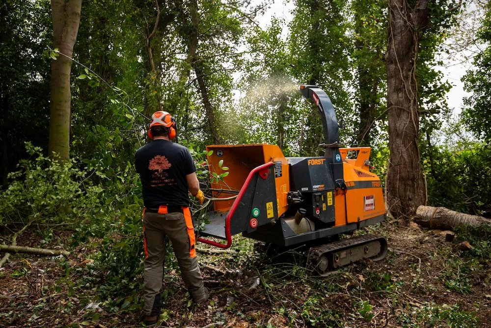 Tracked wood chipper processing tree branches during professional arboricultural work in the North East